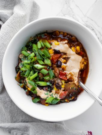White bowl of 30 minute vegan Mexican chili with green onions