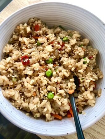 vegan fried rice in white bowl with black spoon