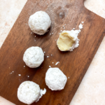 wood platter with vegan white chocolate truffles on it