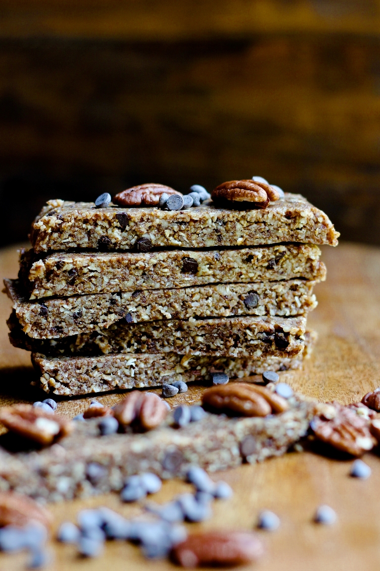 stack of vegan pecan pie bars with chocolate chips on wooden board