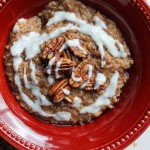 overhead shot of red bowl of cinnamon roll oatmeal with icing