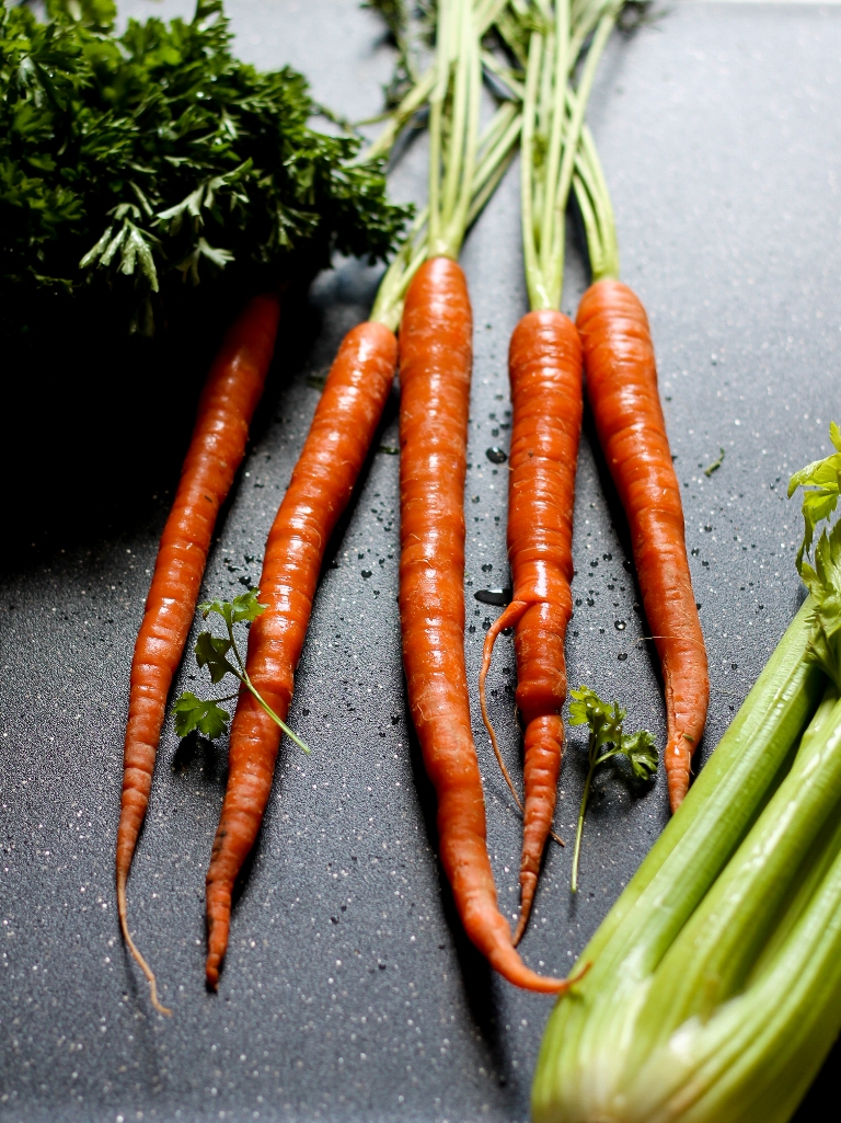 several carrots with stems on black board