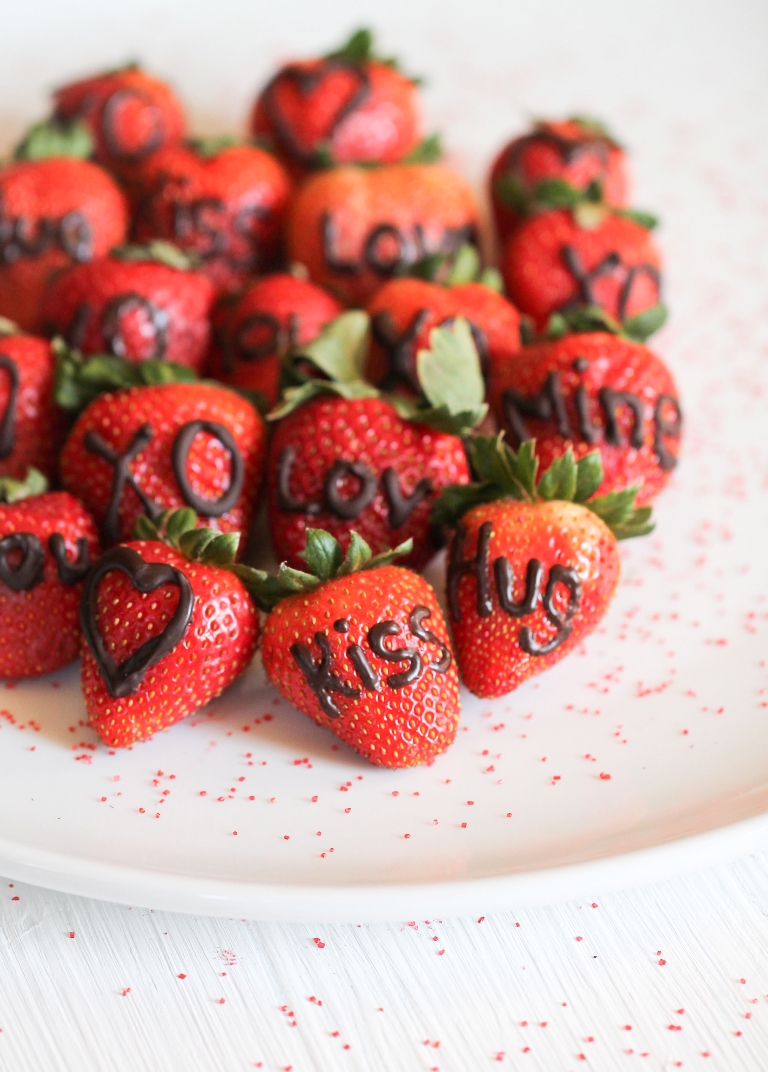 White plate of strawberries with chocolate words