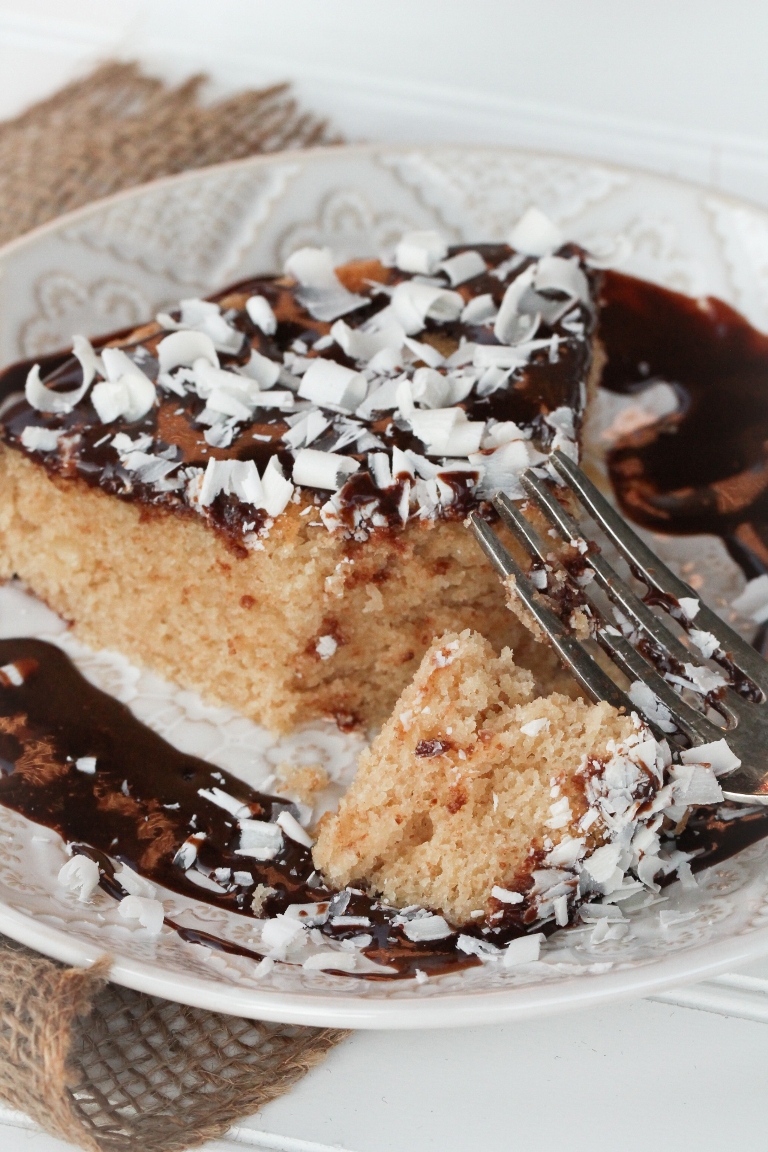 Slice of vegan gluten-free vanilla cake with chocolate ganache
