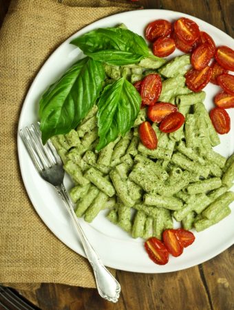 white plate of basil pesto with roasted cherry tomatoes