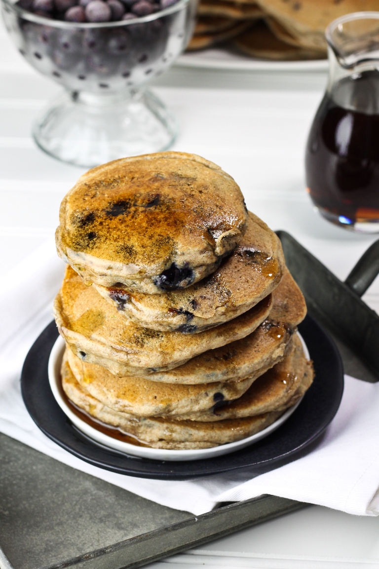 Top view of tall stack of blueberry pancakes on plate