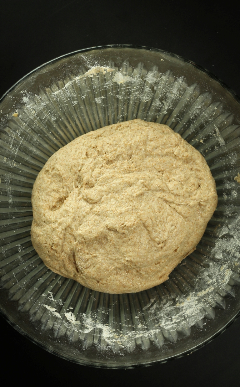 Kneaded bread dough in glass bowl