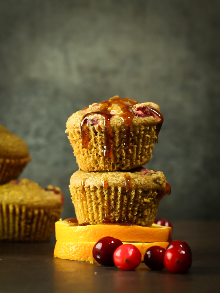 2 vegan orange cranberry muffins stacked on top of each other