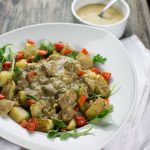large white bowl with roasted potatoes and mushroom gravy