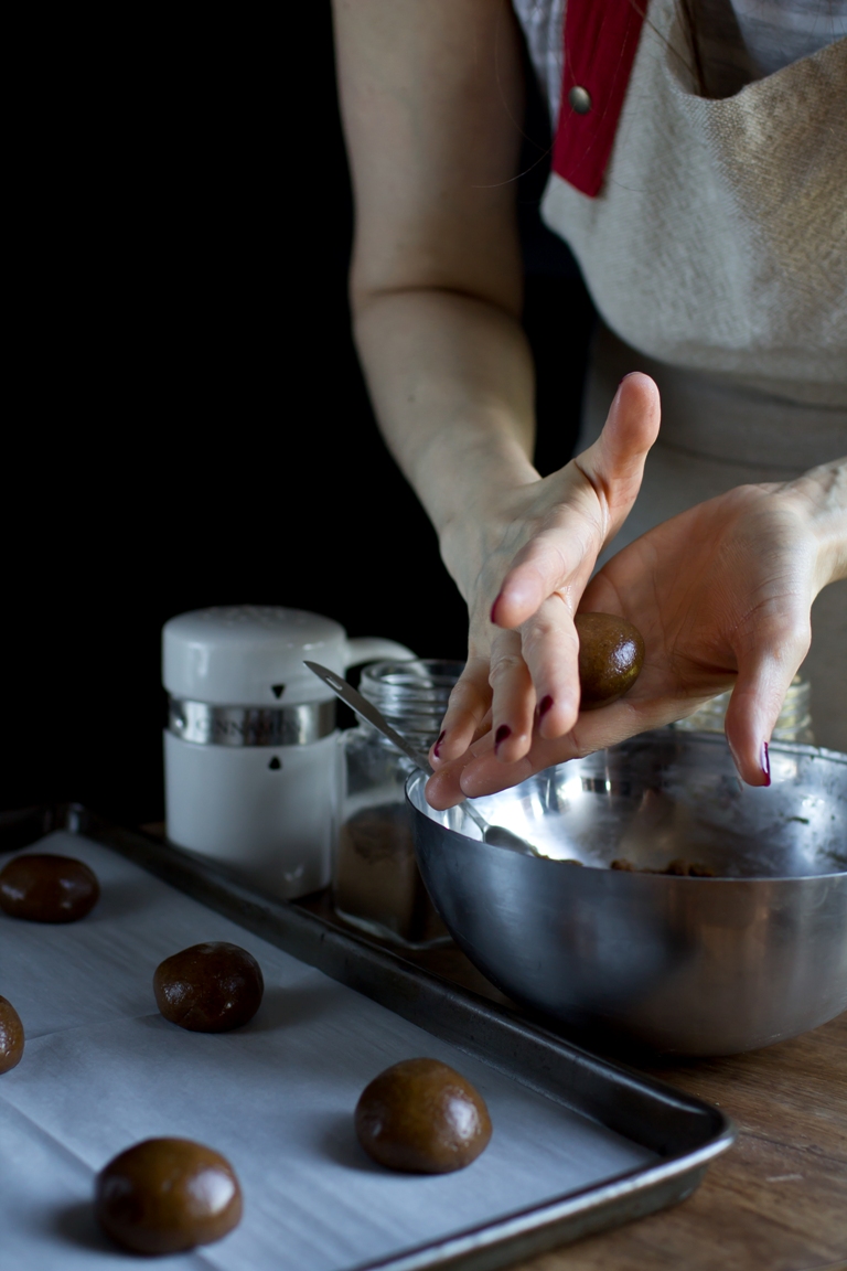 hands rolling vegan gingersnap cookie dough into balls
