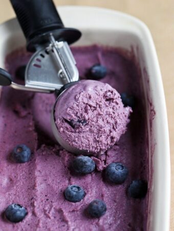 ice cream scoop in dish of blueberry ice cream
