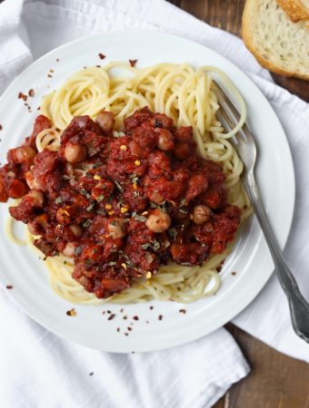 vegan chickpea tomato ragu with spaghetti on white plate