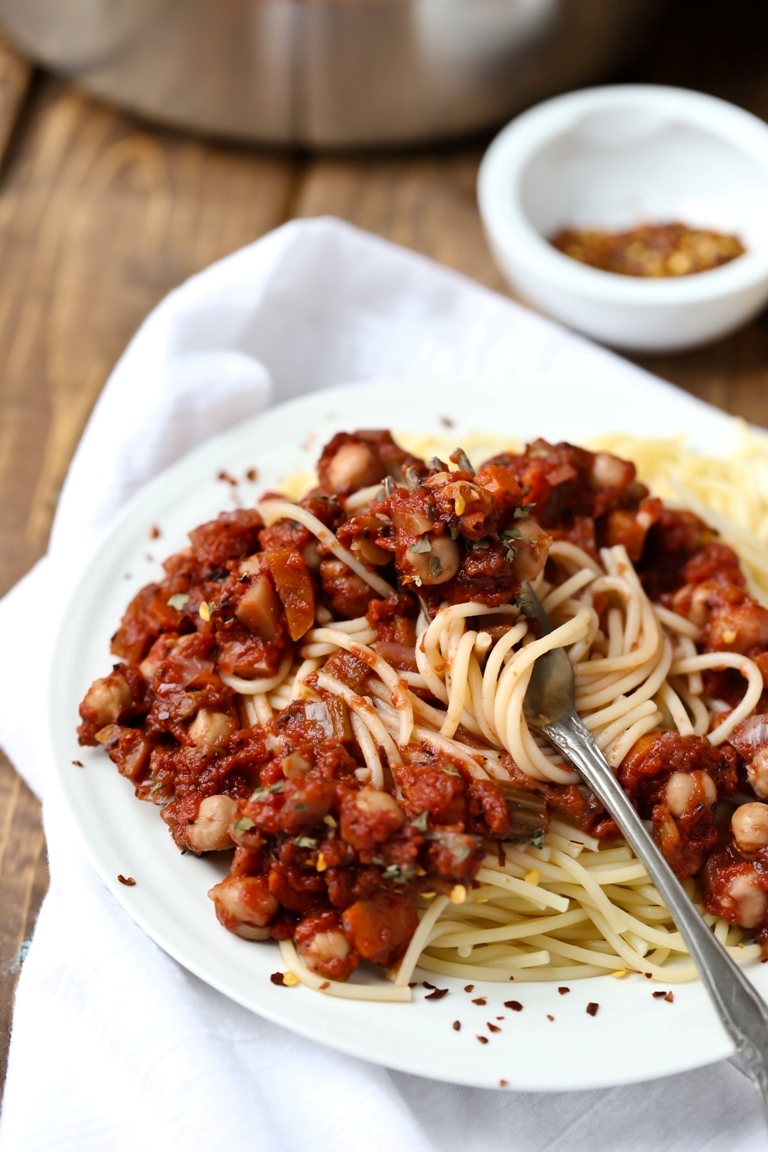 closeup view of fork twirling spaghetti in ragu sauce