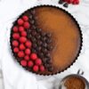overhead shot of chocolate sweet potato tart with chocolate hearts and raspberries