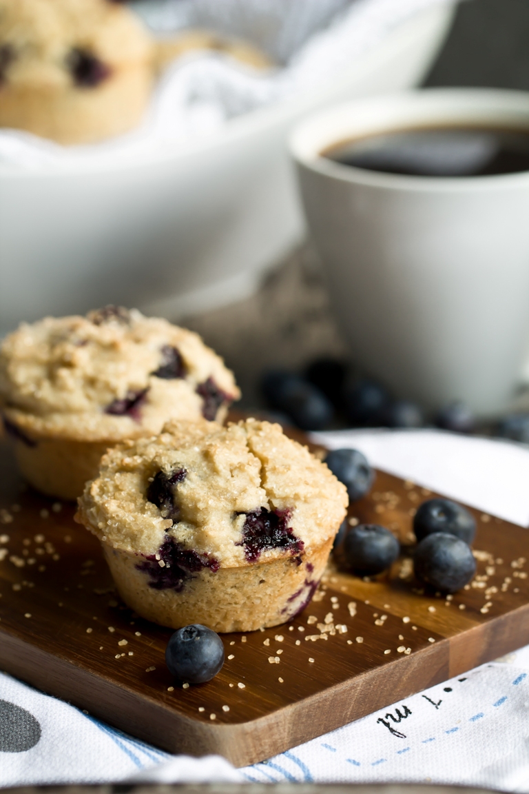 2 vegan blueberry muffins on wood platter