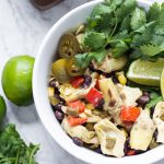 Roasted Artichoke Salad in white bowl with lime