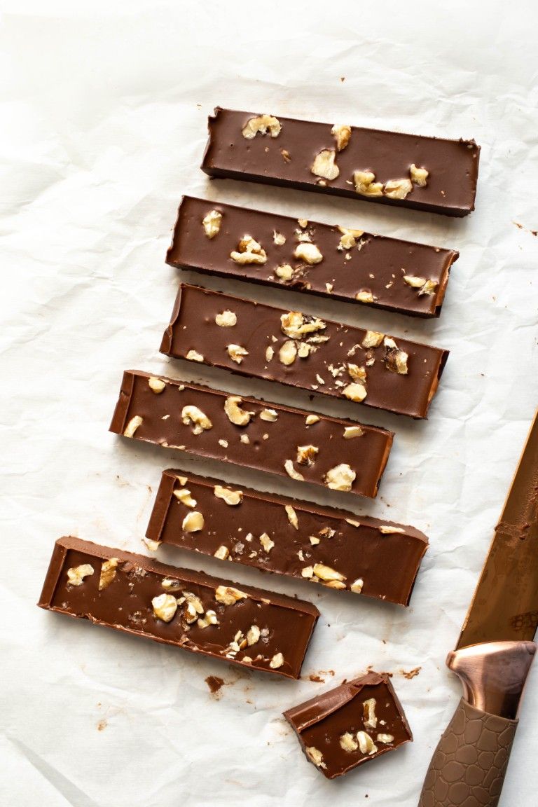several bars of vegan fudge with walnuts on white paper