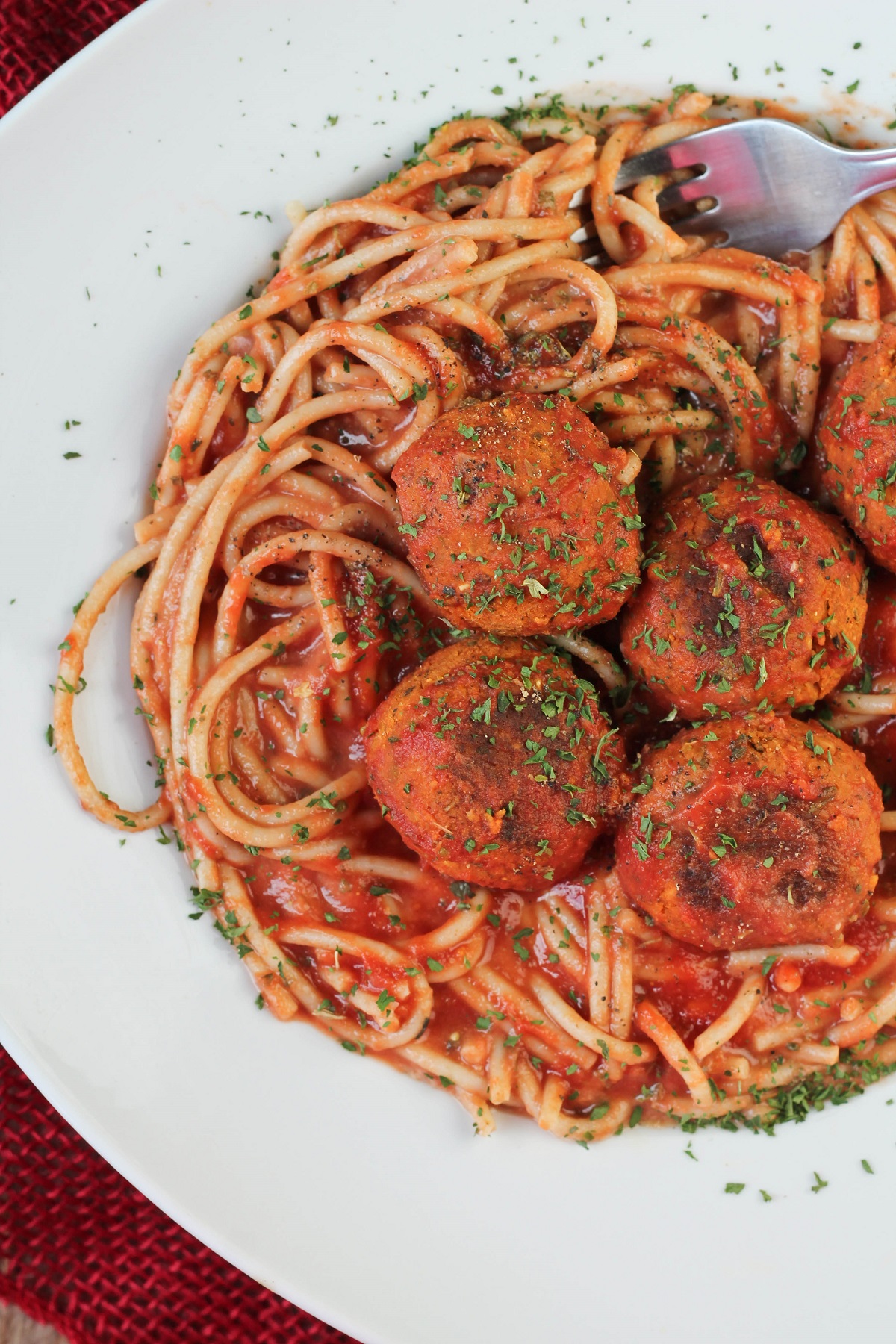 white plate of spaghetti and vegan meatballs