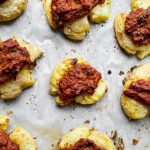 overhead view of smashed potatoes and sundried tomato pesto