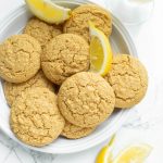 gorgeous bright shot of several lemon cookies with fresh lemon