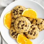plate of orange chocolate chip cookies with orange slices