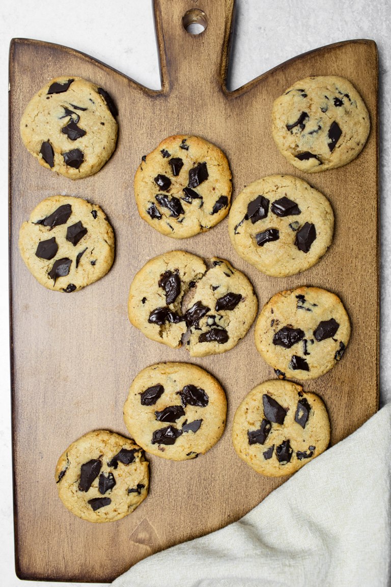 cashew butter cookies with melted chocolate on wooden board