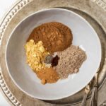 chai spices separated in gray bowl over silver platter