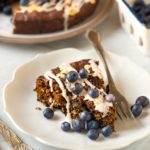 closeup of slice of cake with icing and blueberries