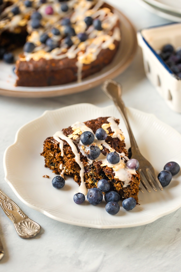 closeup of slice of cake with icing and blueberries