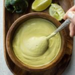 swirling poblano sauce in wooden bowl with spoon