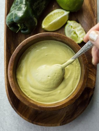 swirling poblano sauce in wooden bowl with spoon