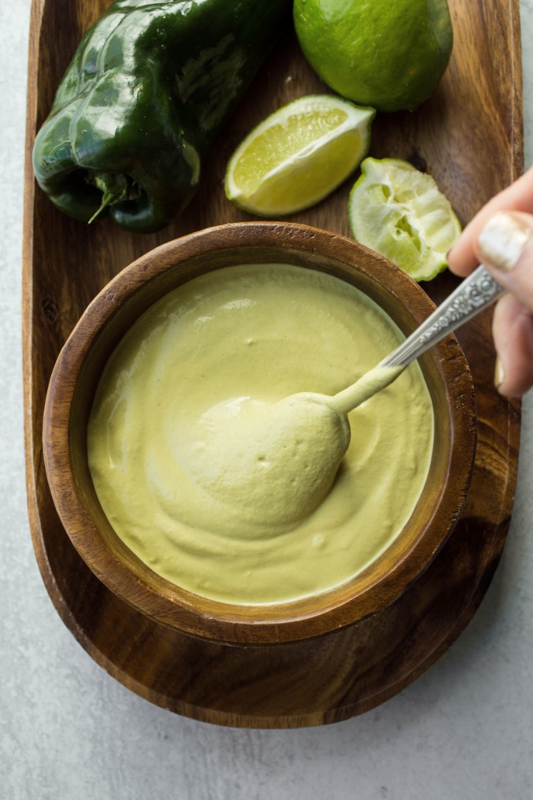 swirling poblano sauce in wooden bowl with spoon