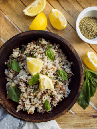wooden bowl of lemon basil rice with fresh lemon wedges