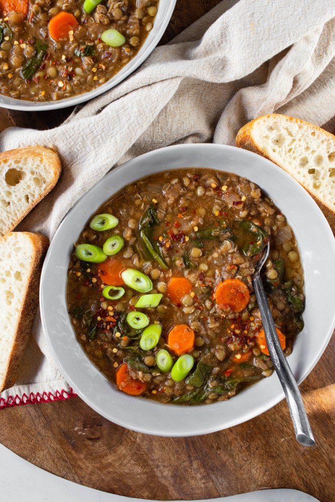 lentil soup in gray bowl with fresh green onions