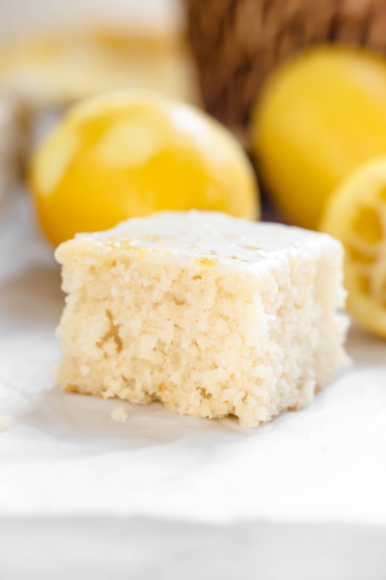 closeup of slice of fluffy cake with lemons in background