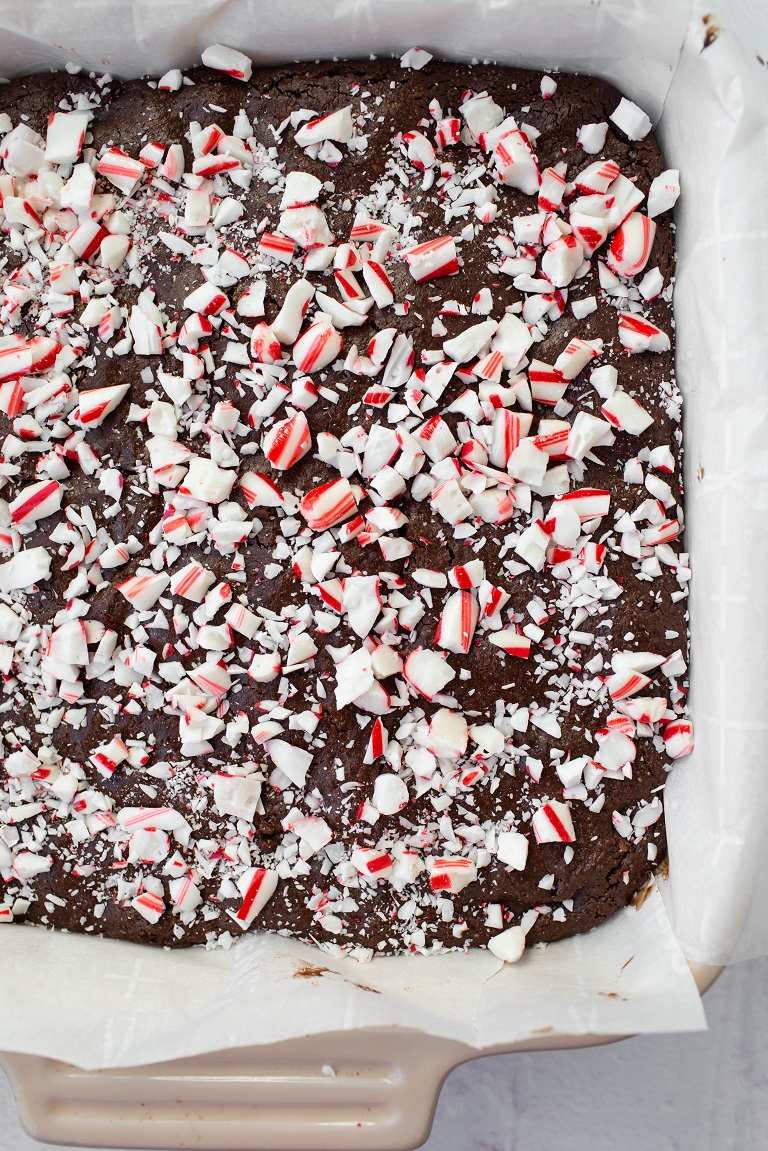 closeup of baked brownies in pan with crushed peppermint candy canes on top