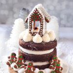 full 3 layer vegan gingerbread cake with frosting and gingerbread house on top