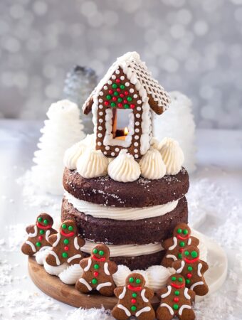 full 3 layer vegan gingerbread cake with frosting and gingerbread house on top
