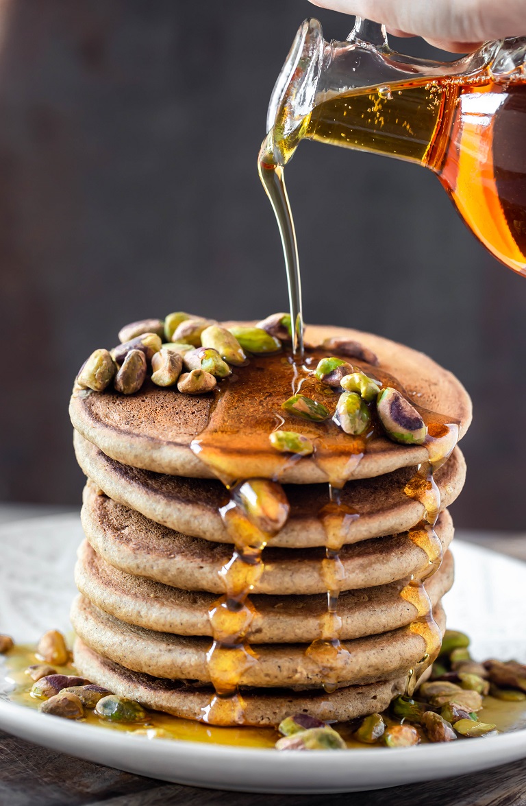 syrup pouring over stack of gluten free gingerbread pancakes