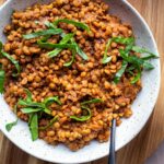 smoky vegan instant pot lentils in white bowl on wood platter