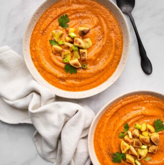 overhead shot of 2 white bowls of instant pot sweet potato soup with towel