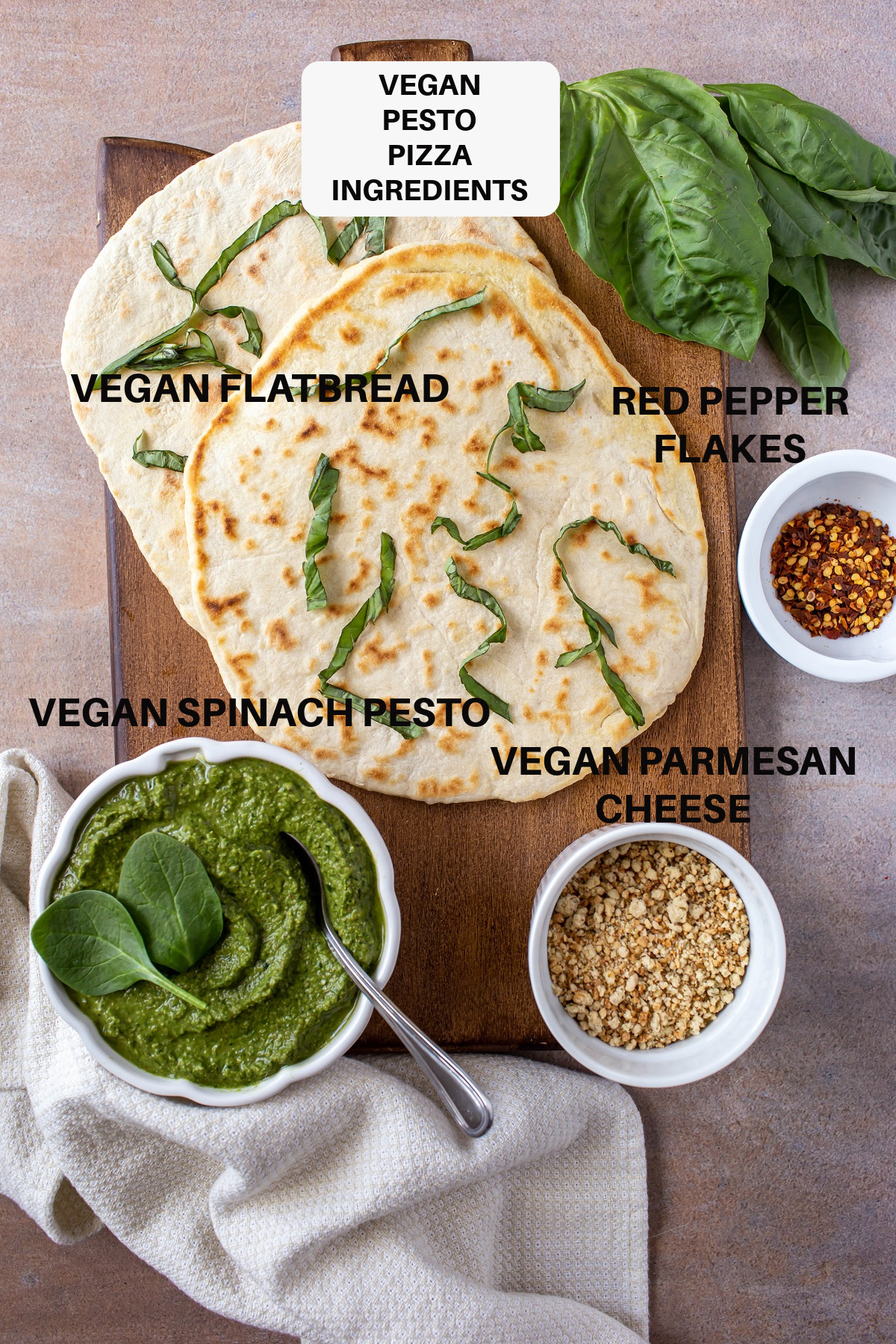 ingredients for vegan pesto pizza on wood board