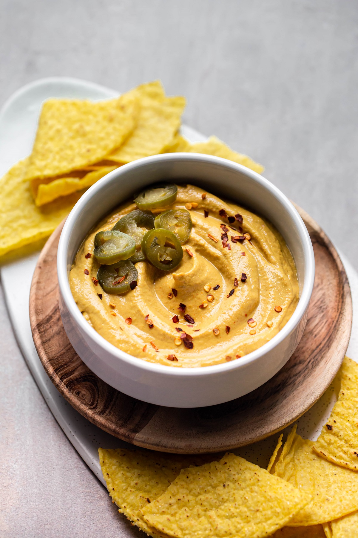 white bowl of vegan nut free queso with jalapeno slices