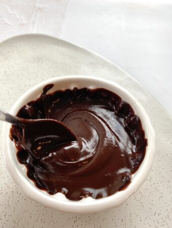 spoon swirling in white bowl of vegan nutella