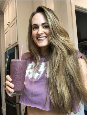 girl holding purple vegan protein smoothie