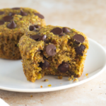 white plate with 2 vegan pistachio chocolate chip muffins