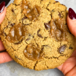 hands holding vegan caramel chocolate chip cookie