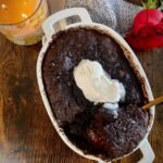 overhead shot of baked chocolate pudding cake with vegan whipped cream