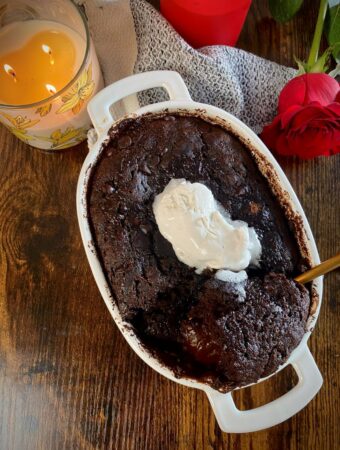 overhead shot of baked chocolate pudding cake with vegan whipped cream