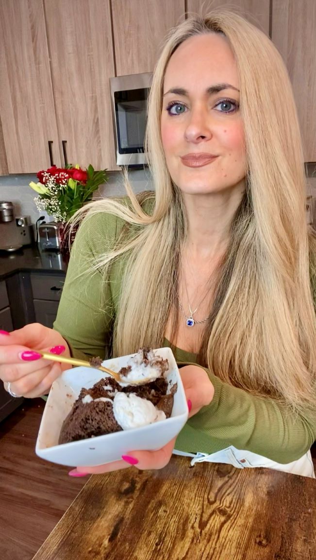 lady holding chocolate cake in white bowl standing in kitchen